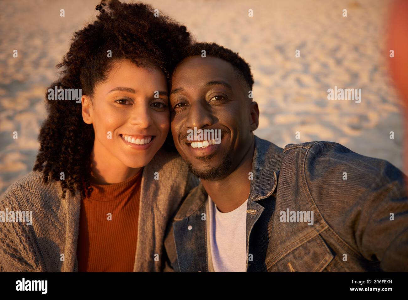 Smiling young multiethnic couple taking a selfie on a sandy beach Stock Photo