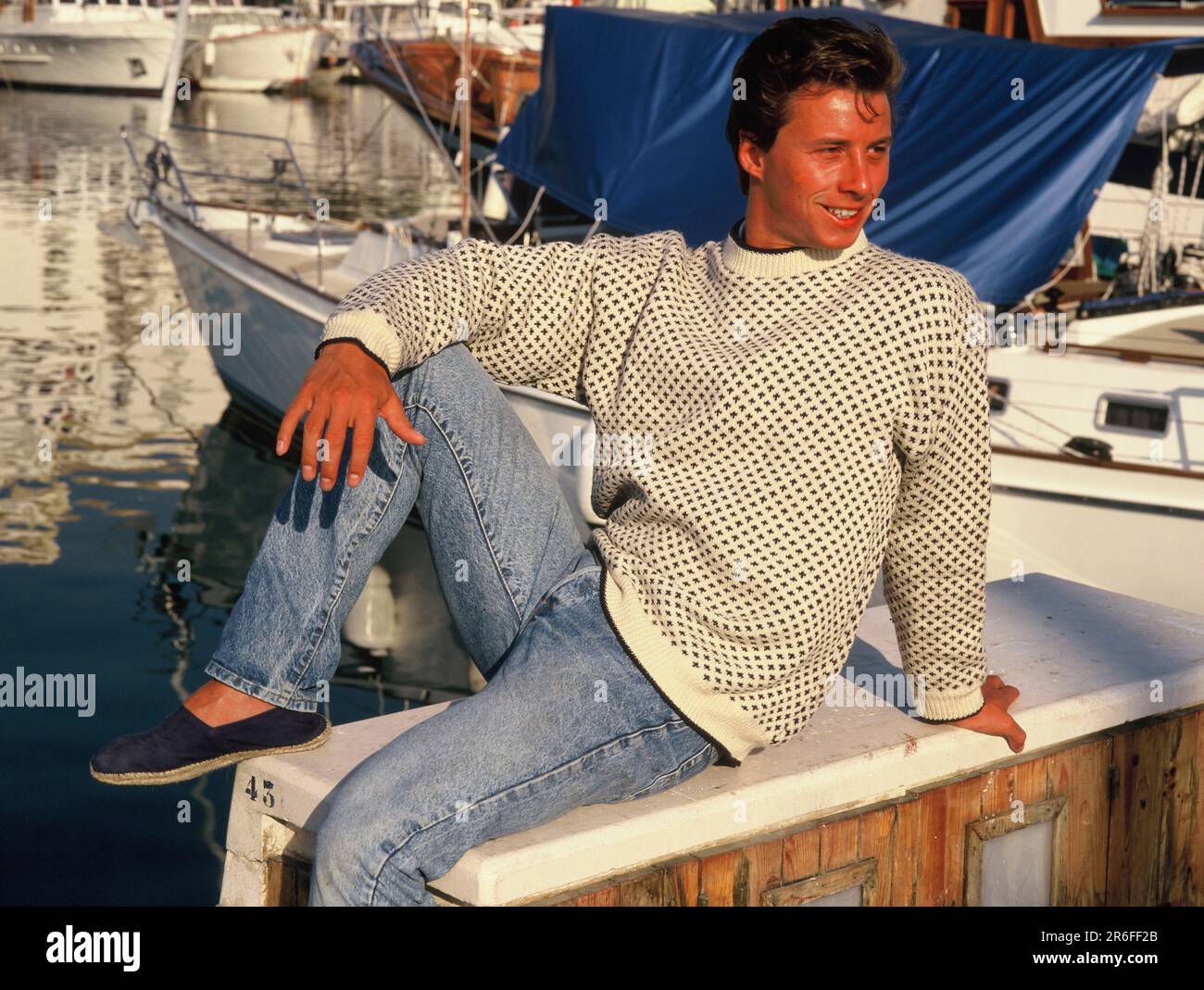 Spain. Marbella. Young man sitting on boat in marina Stock Photo Alamy