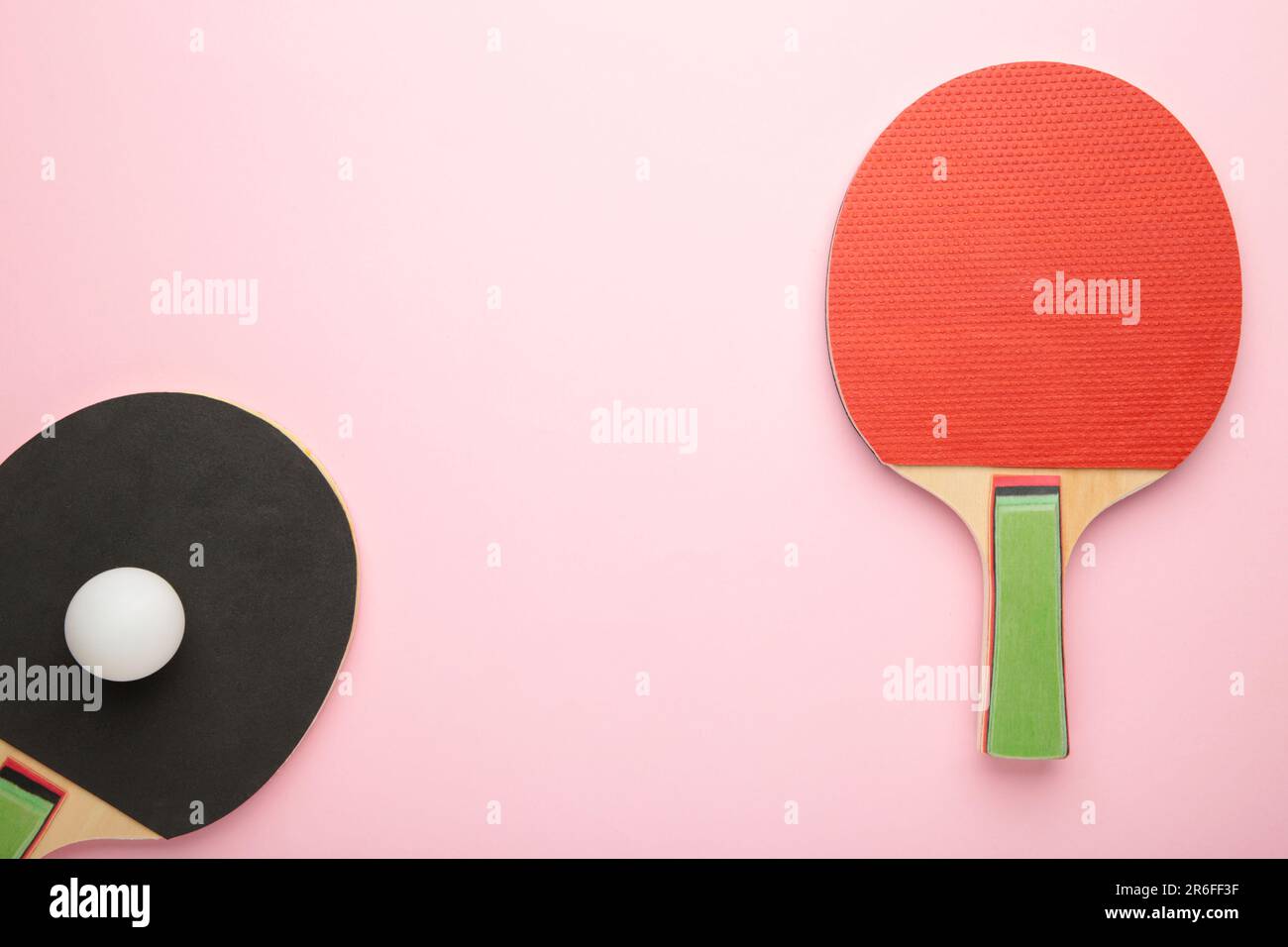 Ping pong rackets and ball on pink background. Top view Stock Photo