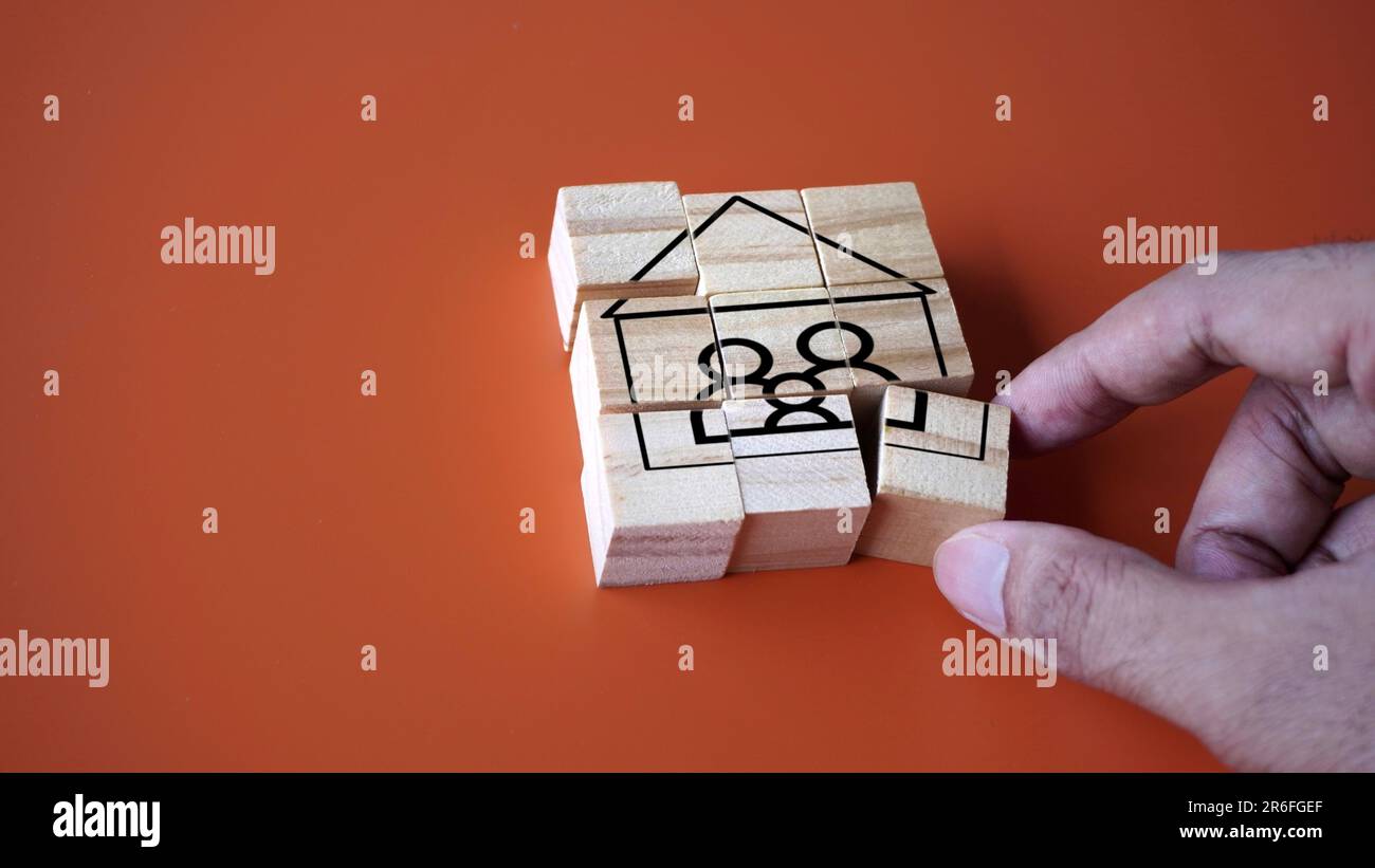 Hand arrange wooden cube with house and family icon. Copy space for text. Settle down, start a family concept Stock Photo