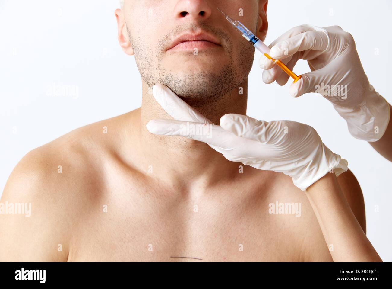 Cropped image of male face against white studio background. Cosmetologists doing beauty injections. Anti-wrinkles care Stock Photo