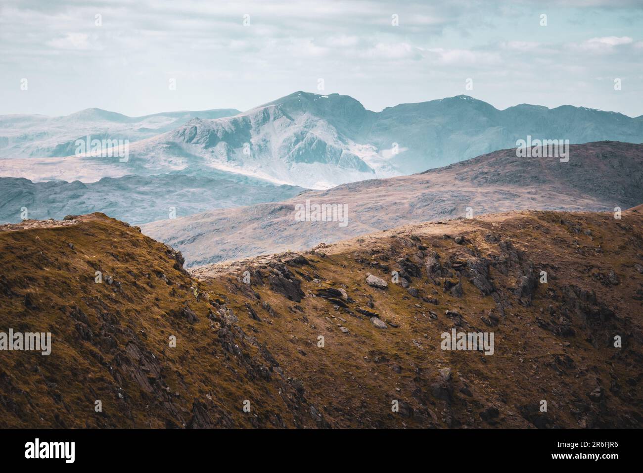 Layers of peaks and mountains stacked from the foreground to background with varying colours in the haze Stock Photo