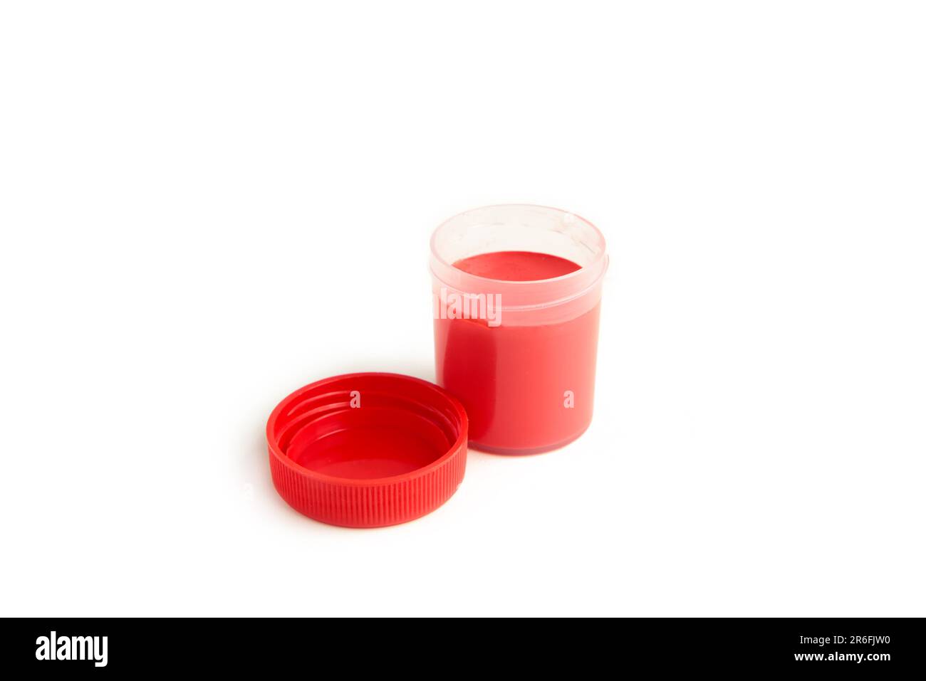 Red gouache jars and primary color acrylic paints on white background. Stock Photo