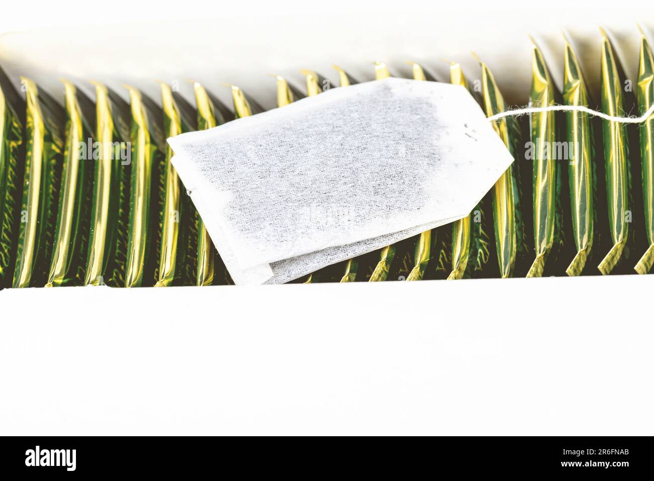 A closeup of a white tea bag with string and tag suspended Stock Photo Alamy