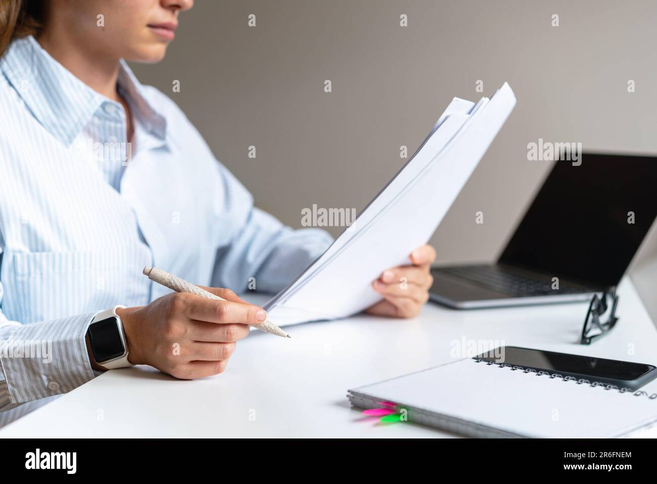 A woman manager sits at a table in the office and reads a business agreement, contract. Stock Photo
