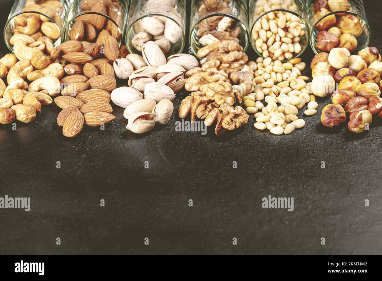 A collection of various nuts, seeds, and legumes stored in glass