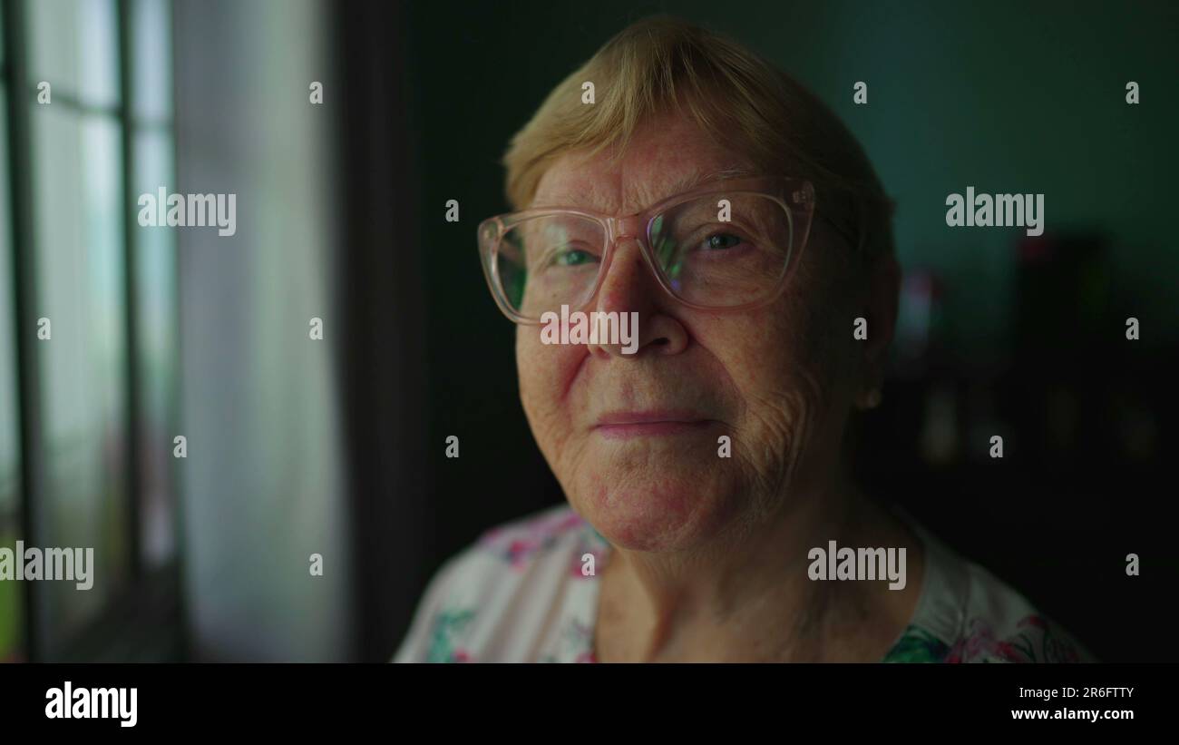 Close-up of elderly senior woman face looking at camera smiling. A ...