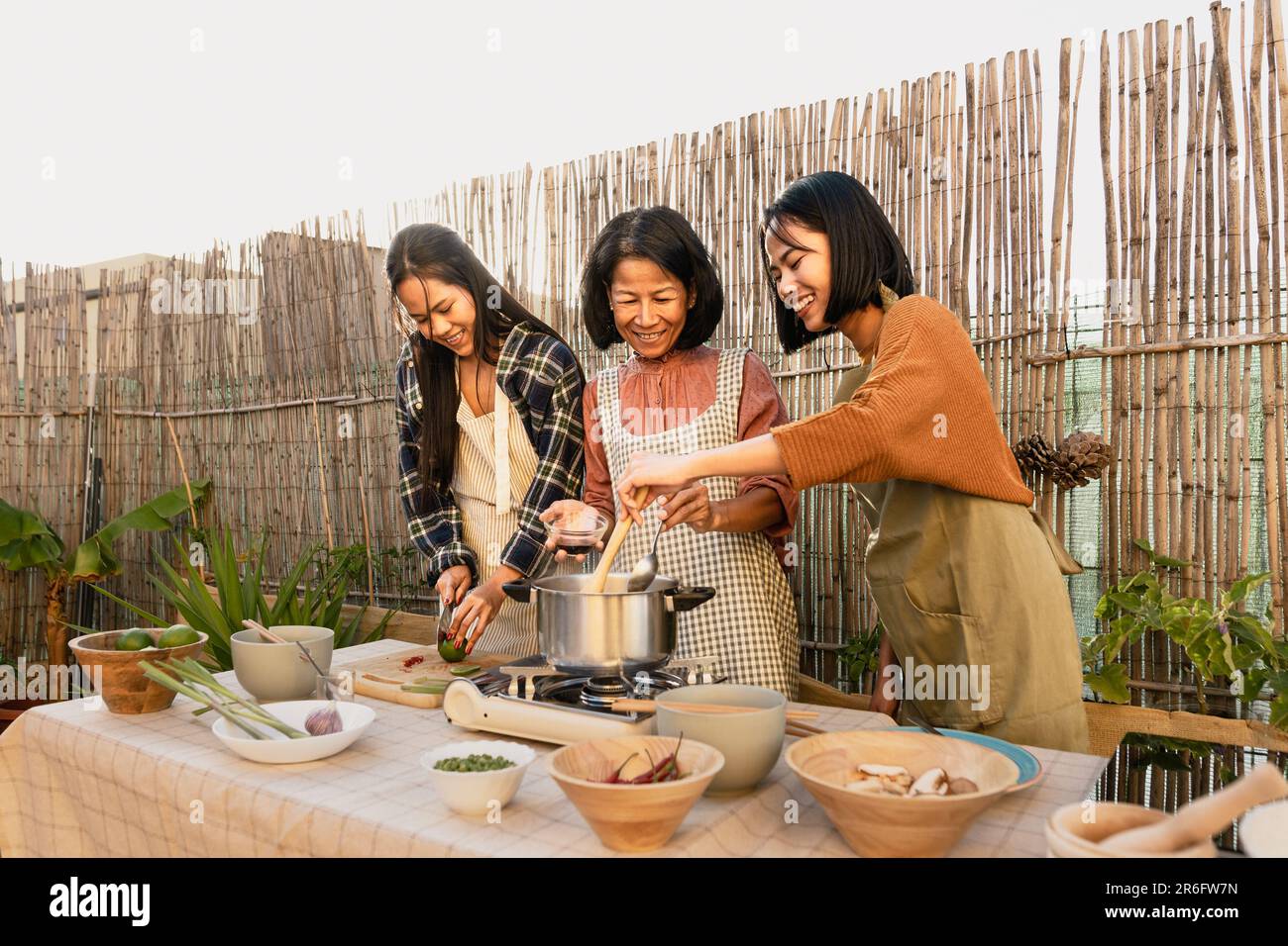 Southeast asian mother with her daughters having fun preparing food