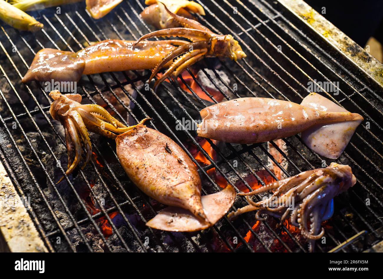 Many squids on a grill in vietnamese night market in food festival ...