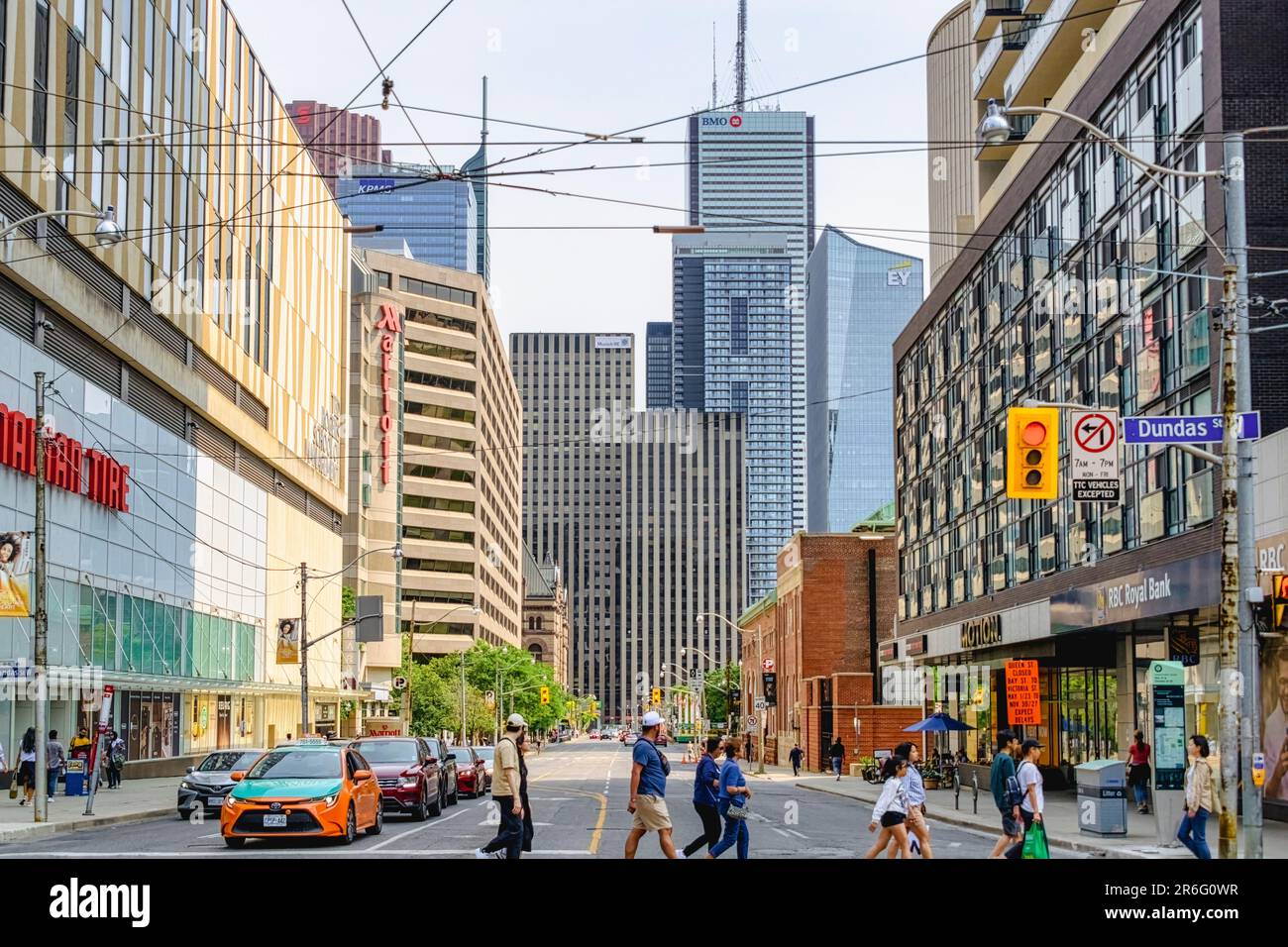 Toronto, Canada - June 4, 2023: Pedestrians crossing Dundas Street W. Cars wait for the people to cross. Stock Photo