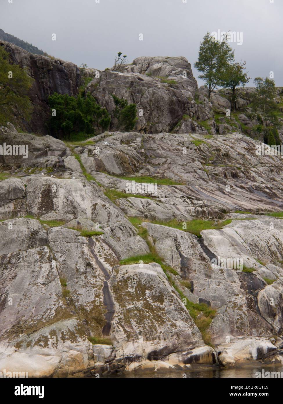 A tranquil landscape featuring a grassy island with rocks and a serene ...
