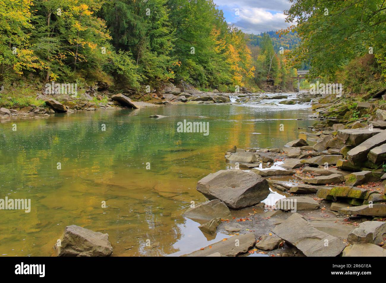 The photo was taken in the Ukrainian city of Yaremche. The photo shows an autumn landscape of the river called the Prut, in a mountainous wooded area. Stock Photo