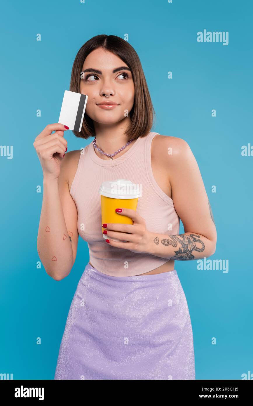 to go coffee, young woman with short hair, tattoos and nose piercing ...