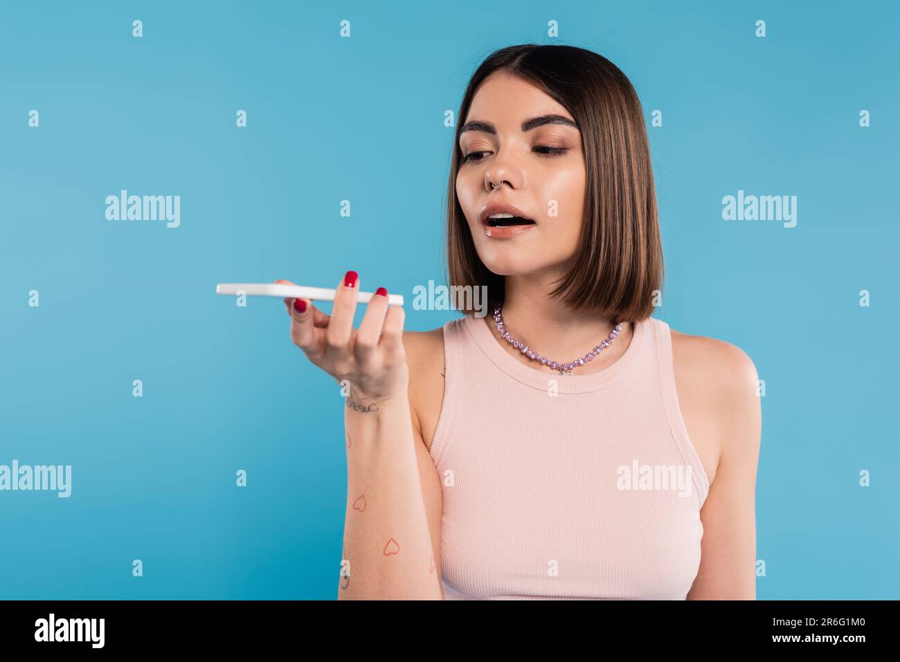 voice message, young woman with short hair, tattoos and nose piercing