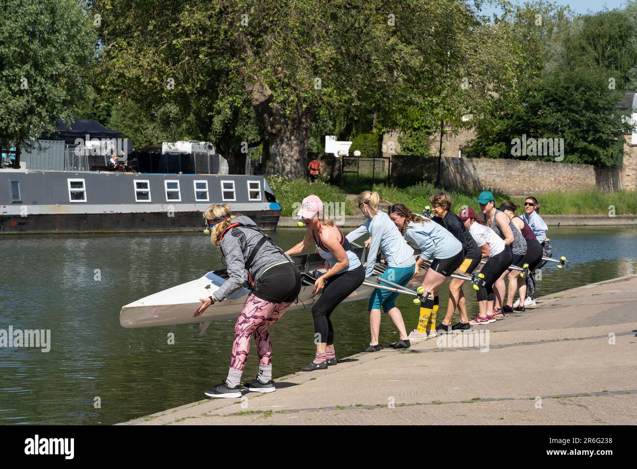 Women rowers putting a rowing boat in the River Cam in Cambridge Stock Photo