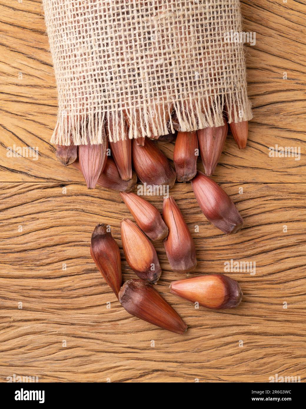 Pinions or pine tree seeds on a bag over wooden table. Stock Photo
