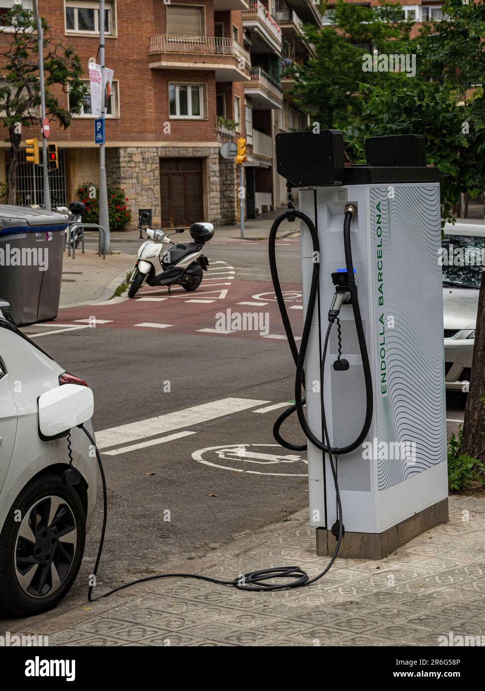 Hybrid car recharging the battery at a public recharging point, on a