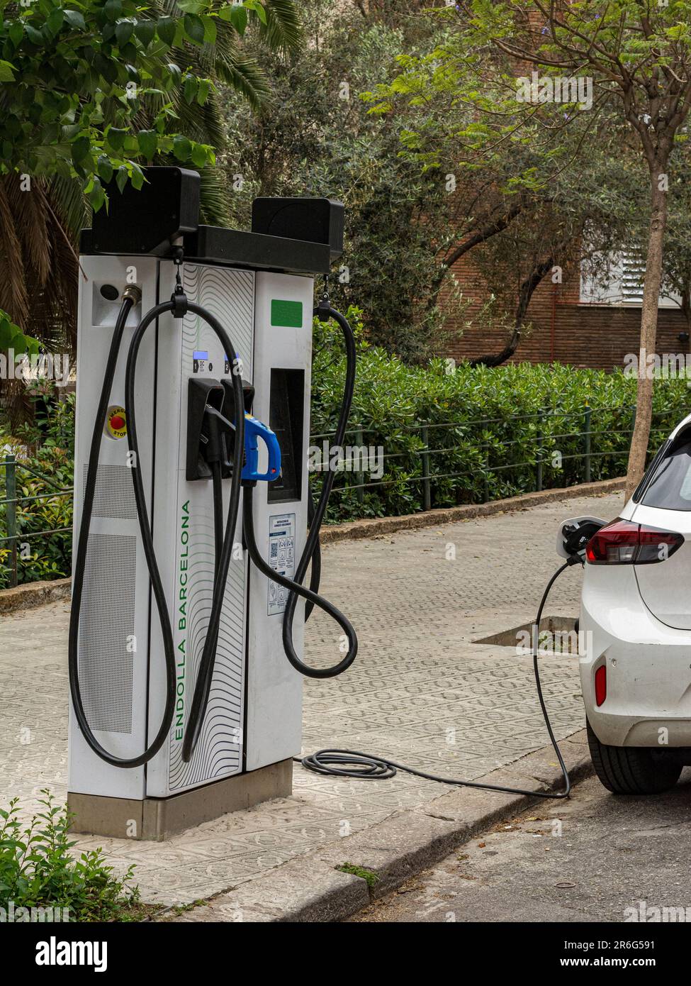 Hybrid car recharging the battery at a public recharging point, on a