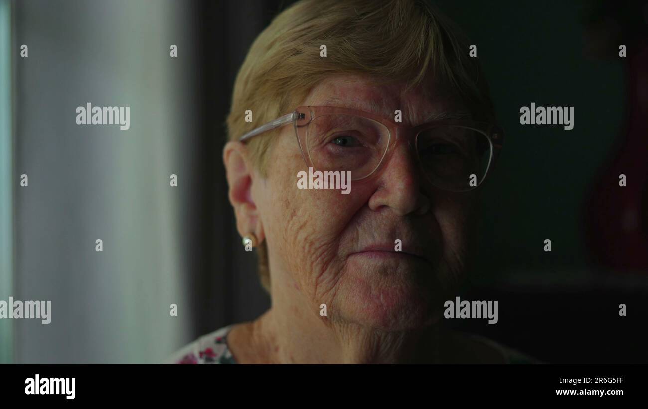 Elderly senior woman close-up face looking at camera with serious ...