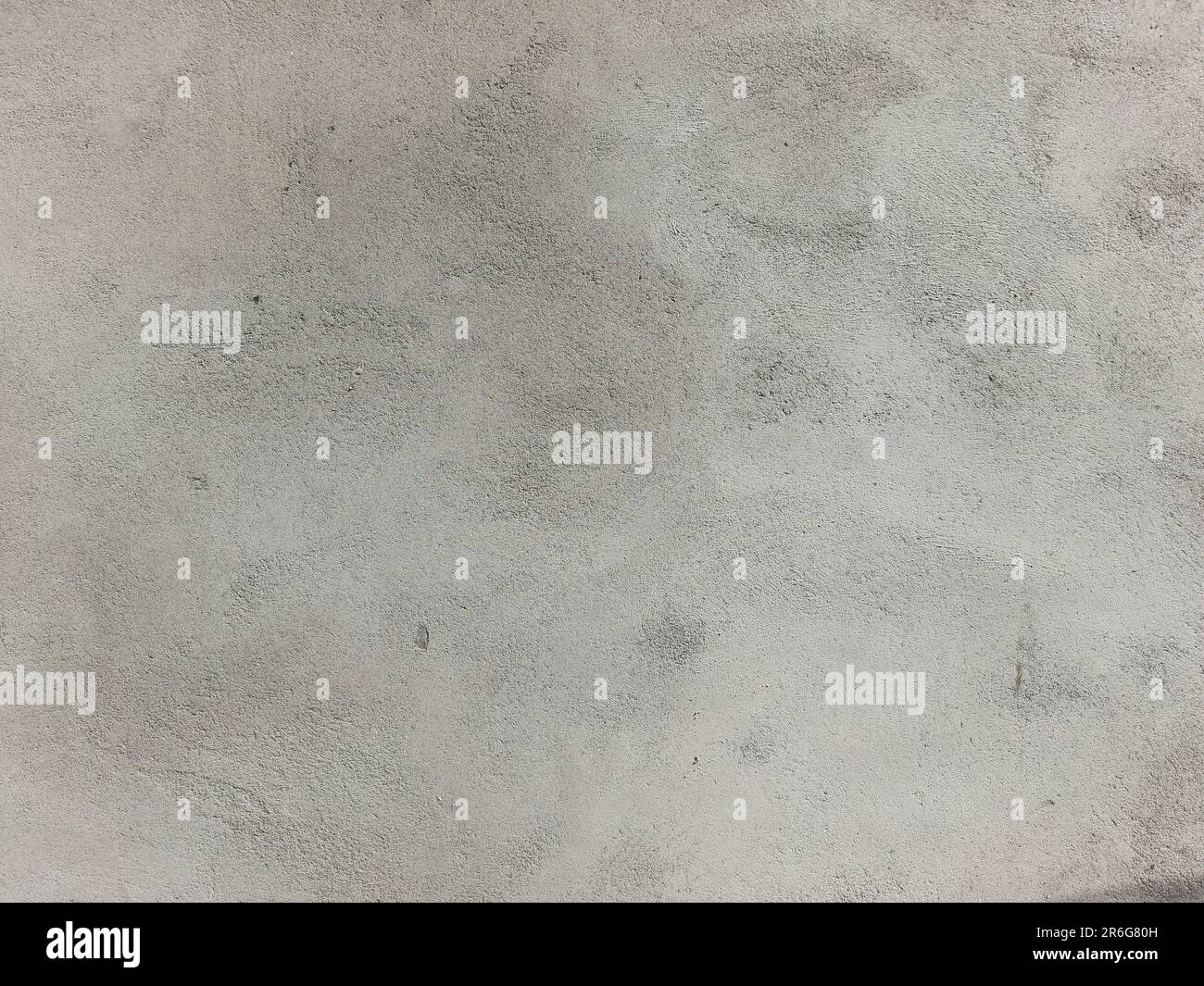 A closeup shot of a white cement surface featuring a corner with black