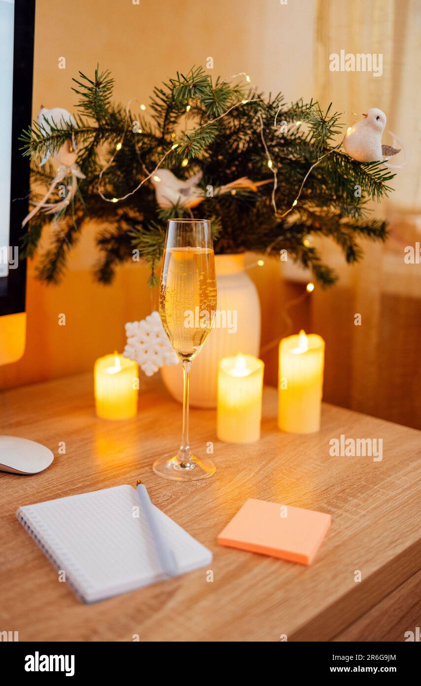 Christmas decorations at cozy workplace with champagne. Computer and
