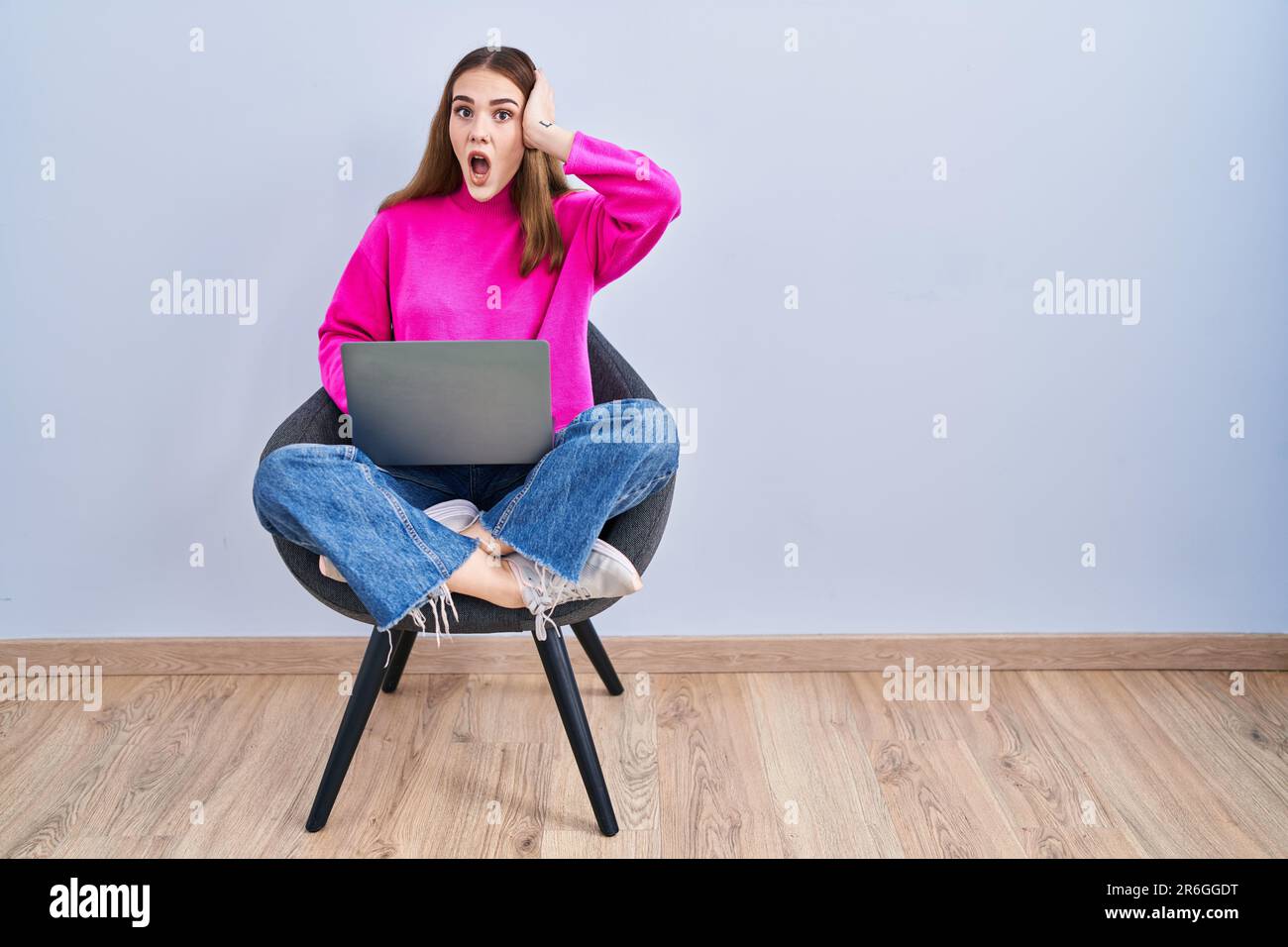 Young hispanic girl working using computer laptop crazy and scared with ...