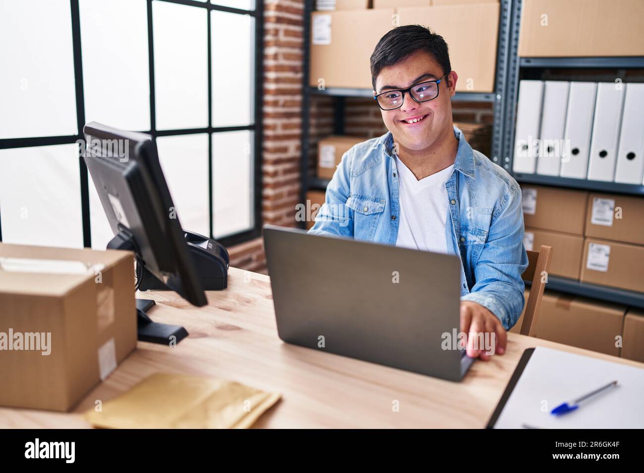 Down syndrome man ecommerce business worker using laptop working at office Stock Photo