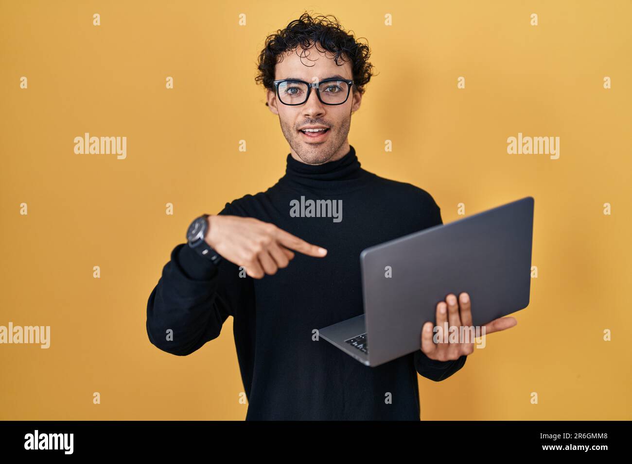 Hispanic Man Using Computer Hispanic man working using computer laptop smiling happy pointing with ...