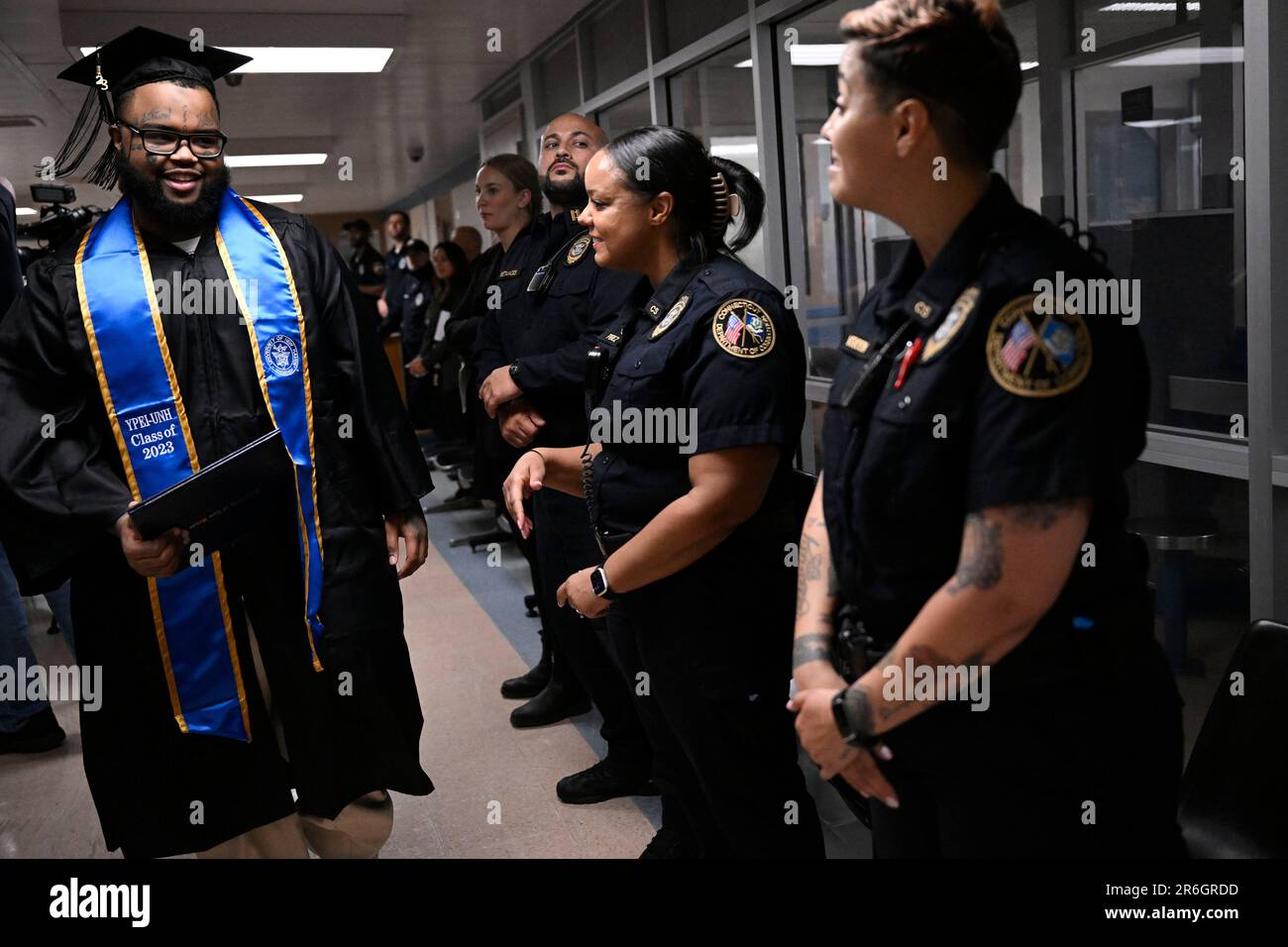Graduate Alpha Jalloh walks with his diploma past correction officers