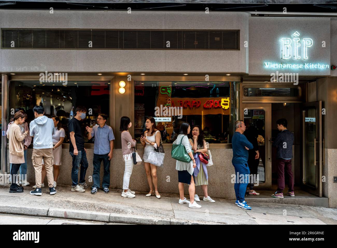 Young People Queue Outside The BEP Vietnamese Kitchen During Lunchtime, Hong Kong Island, Hong Kong, China. Stock Photo