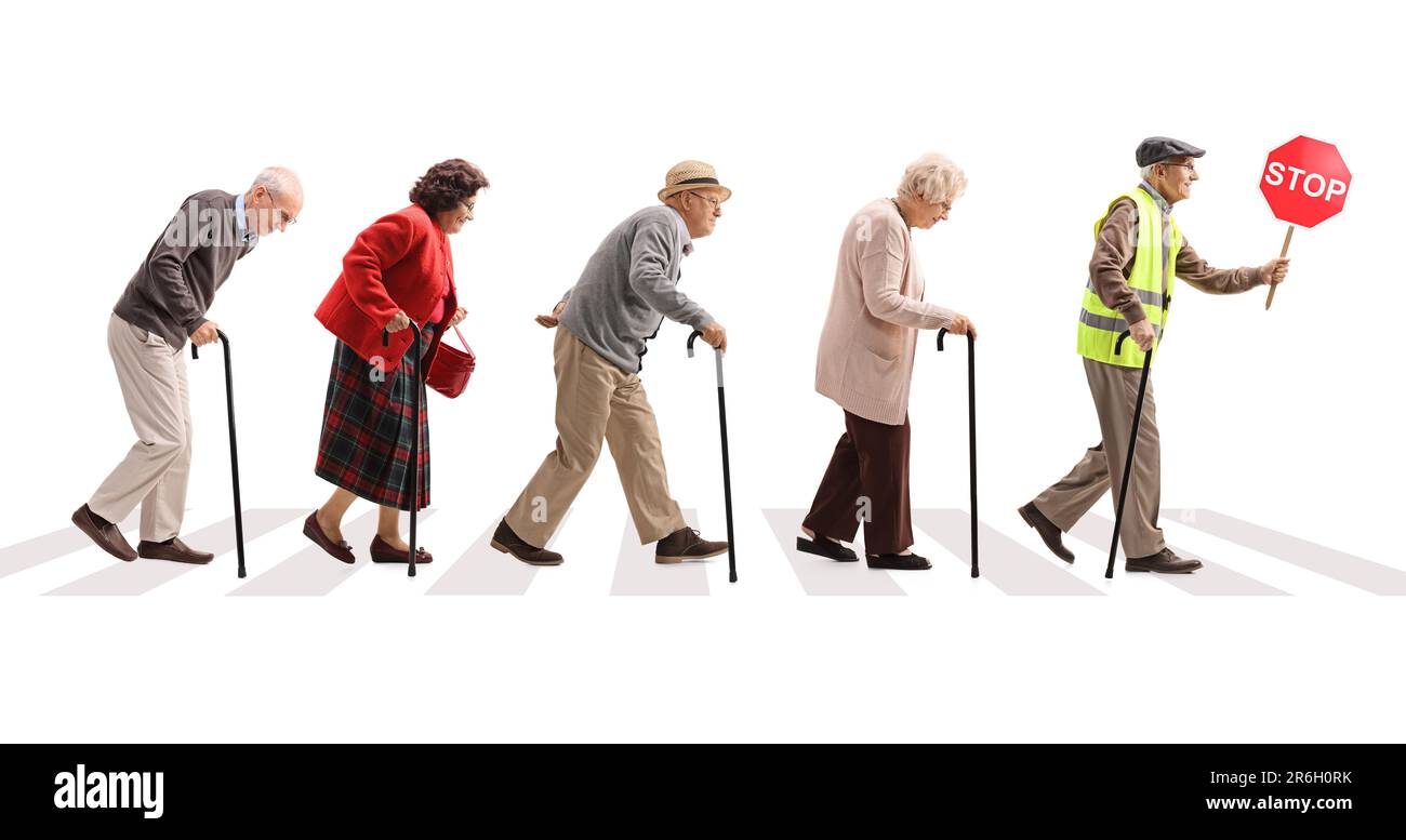Full length profile shot of a group of senior people walking at a pedestrian crossing isolated on white background Stock Photo