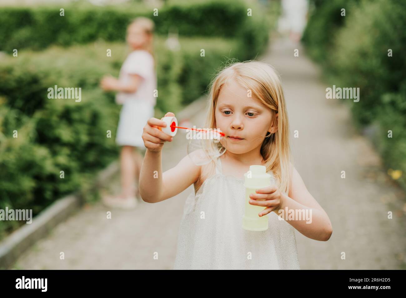 Little girl playing outside with soap bubbles Stock Photo - Alamy