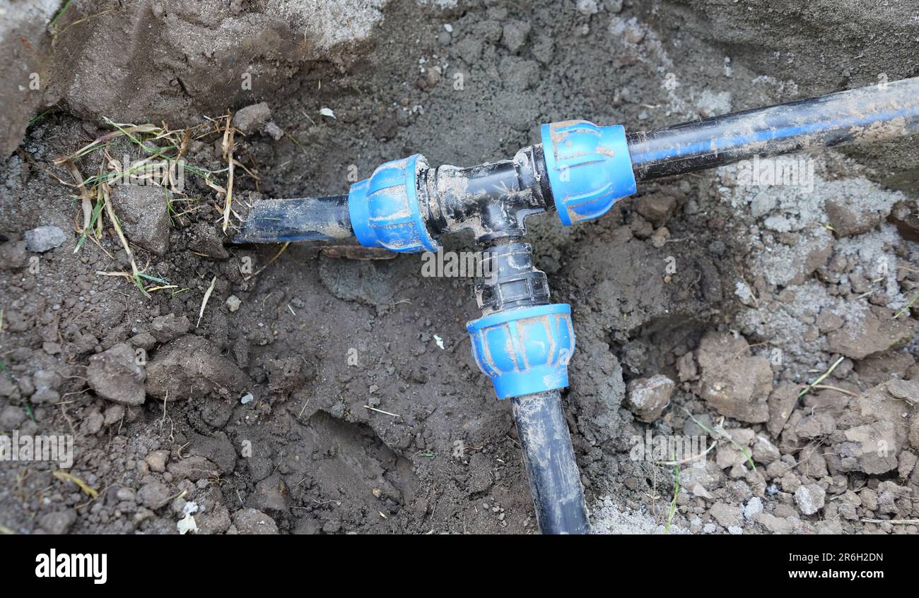 Instalation of blue plastic water pipes under the ground. Connected instalation of water pipes