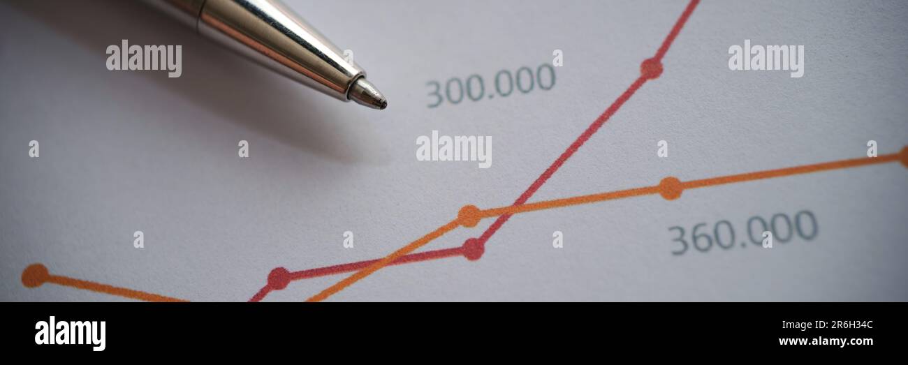 Silver pen on documents with colourful graphs with intersecting lines Stock Photo