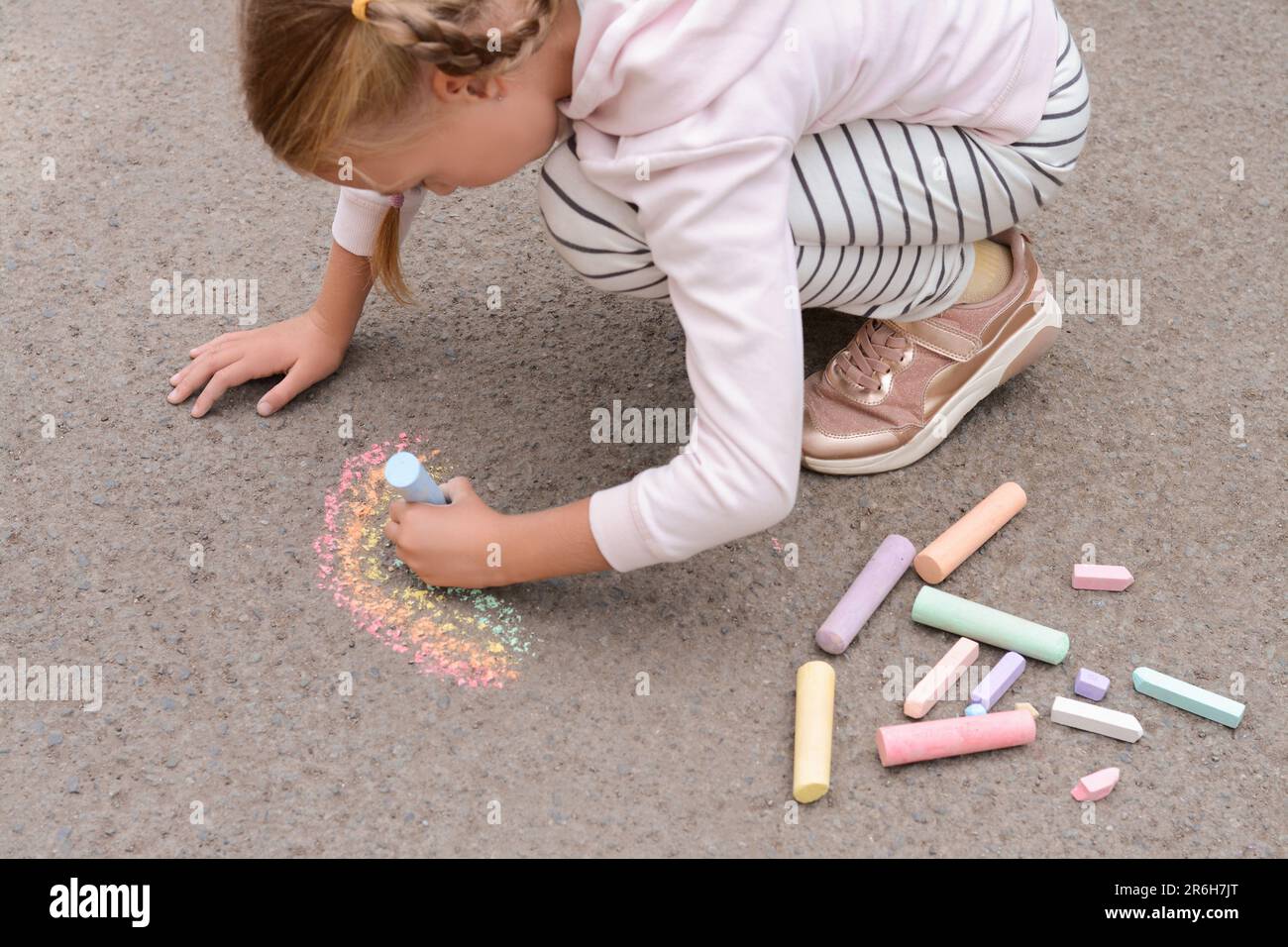 Little child drawing rainbow with chalk on asphalt Stock Photo - Alamy