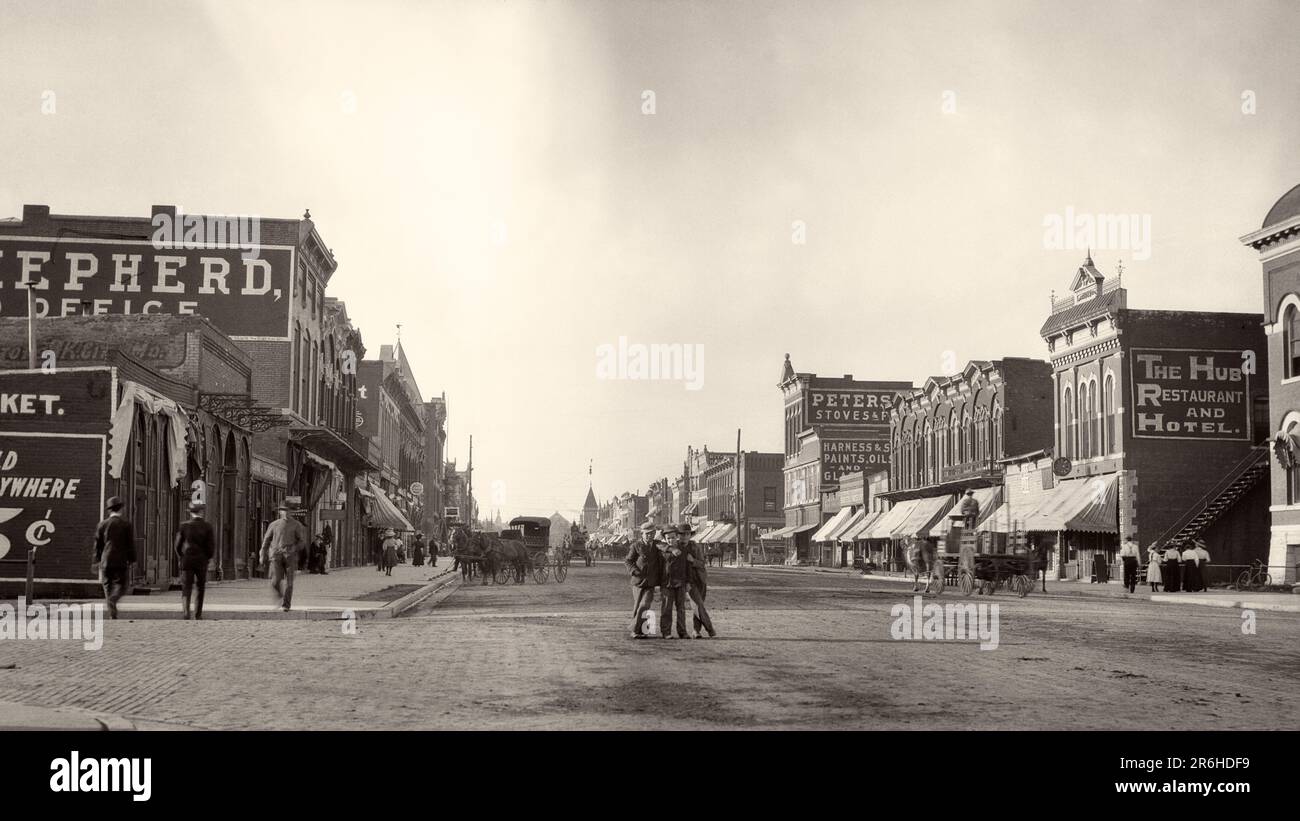 1900s 1910 THREE BOYS STANDING IN CENTER OF COMMERCIAL STREET LOOKING AT CAMERA OTHER MEN WALKING ON SIDEWALK EMPORIA KANSAS USA - q45703 CPC001 HARS ARCHITECTURE TRANSPORT UNITED STATES COPY SPACE FRIENDSHIP FULL-LENGTH PERSONS UNITED STATES OF AMERICA MALES KANSAS BUILDINGS WHEELS TRANSPORTATION B&W NORTH AMERICA NORTH AMERICAN WIDE ANGLE STRUCTURE URBAN CENTER MAMMALS PROPERTY KS PROGRESS TRIO REAL ESTATE STRUCTURES WAGONS EDIFICE EMPORIA GROWTH MAMMAL TOGETHERNESS BLACK AND WHITE GREAT PLAINS MAIN STREET MIDWEST MIDWESTERN OLD FASHIONED Stock Photo