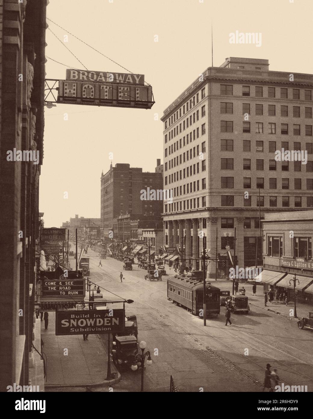 1920s ELEVATED VIEW TROLLEY AT CORNER OF BROADWAY A HOTEL AND A MOVIE THEATER MARQUEE FOR FILM ROAD TO RUIN IN GARY INDIANA USA - q74982 CPC001 HARS AUTOMOBILE CORNER BUILDINGS ENTERTAINMENT TRANSPORTATION B&W MOVIES NORTH AMERICA SHOPPER NORTH AMERICAN SHOPPERS DREAMS STRUCTURE HIGH ANGLE CINEMAS PROPERTY AUTOS IN OF THE STORES TROLLEY INDIANA REAL ESTATE STRUCTURES AUTOMOBILES ELEVATED VEHICLES EDIFICE MOTION PICTURE MOTION PICTURES BROADWAY COMMERCE GROWTH HOTELS BLACK AND WHITE BUSINESSES MIDWEST MIDWESTERN OLD FASHIONED Stock Photo