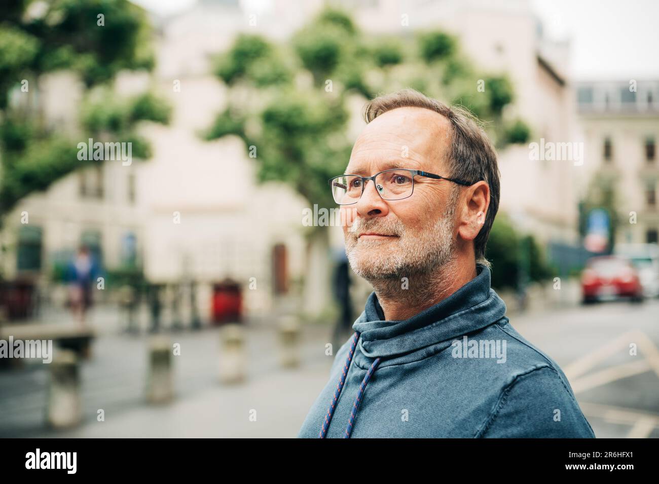 Outdoor portrait of middle age man on city street, wearing eyeglasses and blue sweatshirt Stock Photo