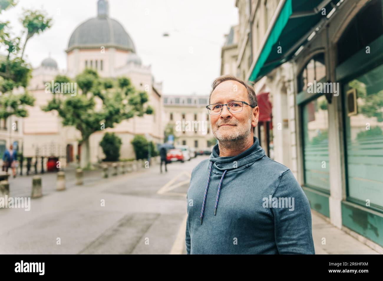 Outdoor portrait of middle age man on city street, wearing eyeglasses and blue sweatshirt Stock Photo