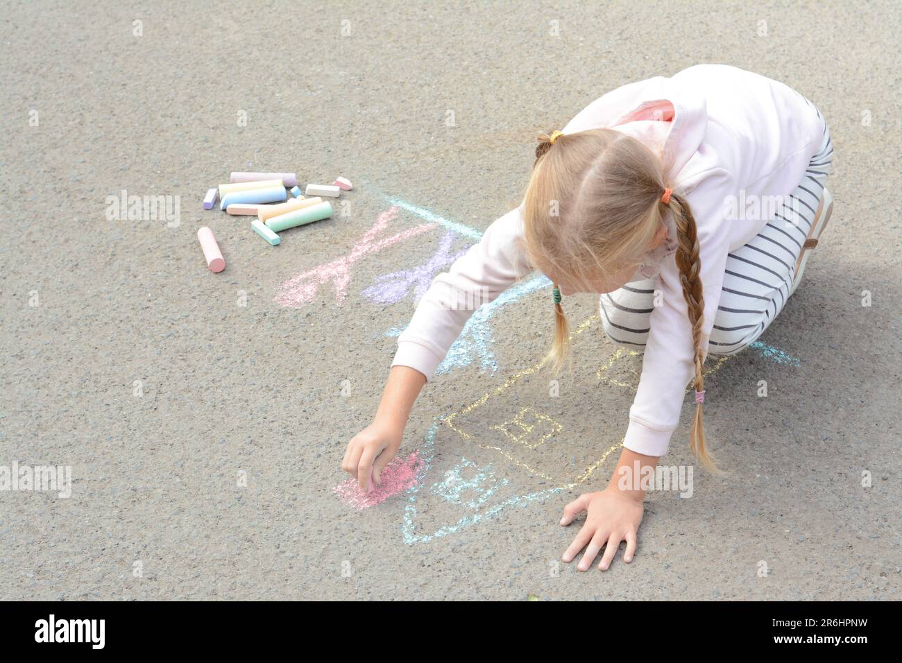 Little child drawing happy family with chalk on asphalt Stock Photo - Alamy