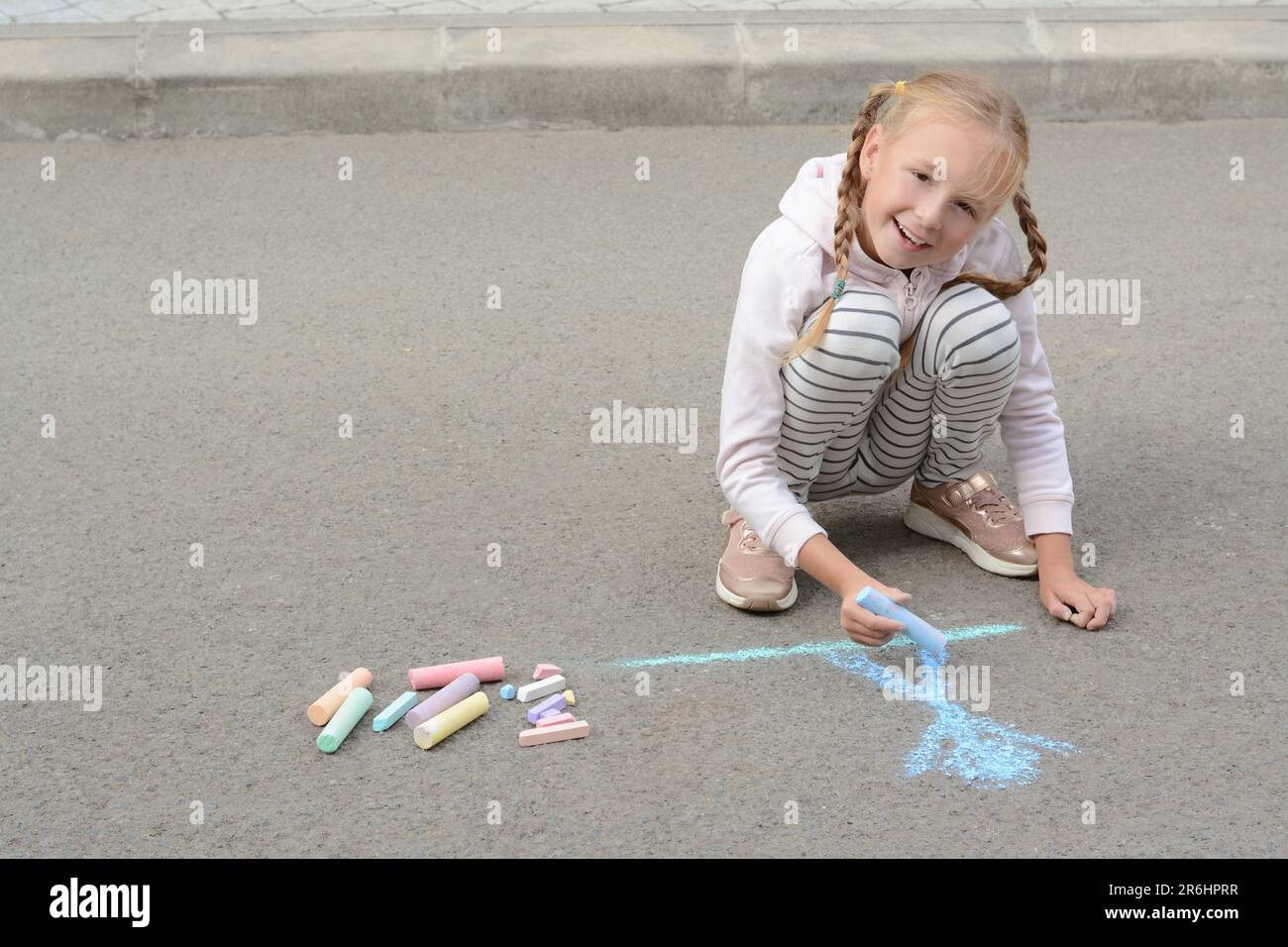 Little child drawing happy family with chalk on asphalt Stock Photo - Alamy