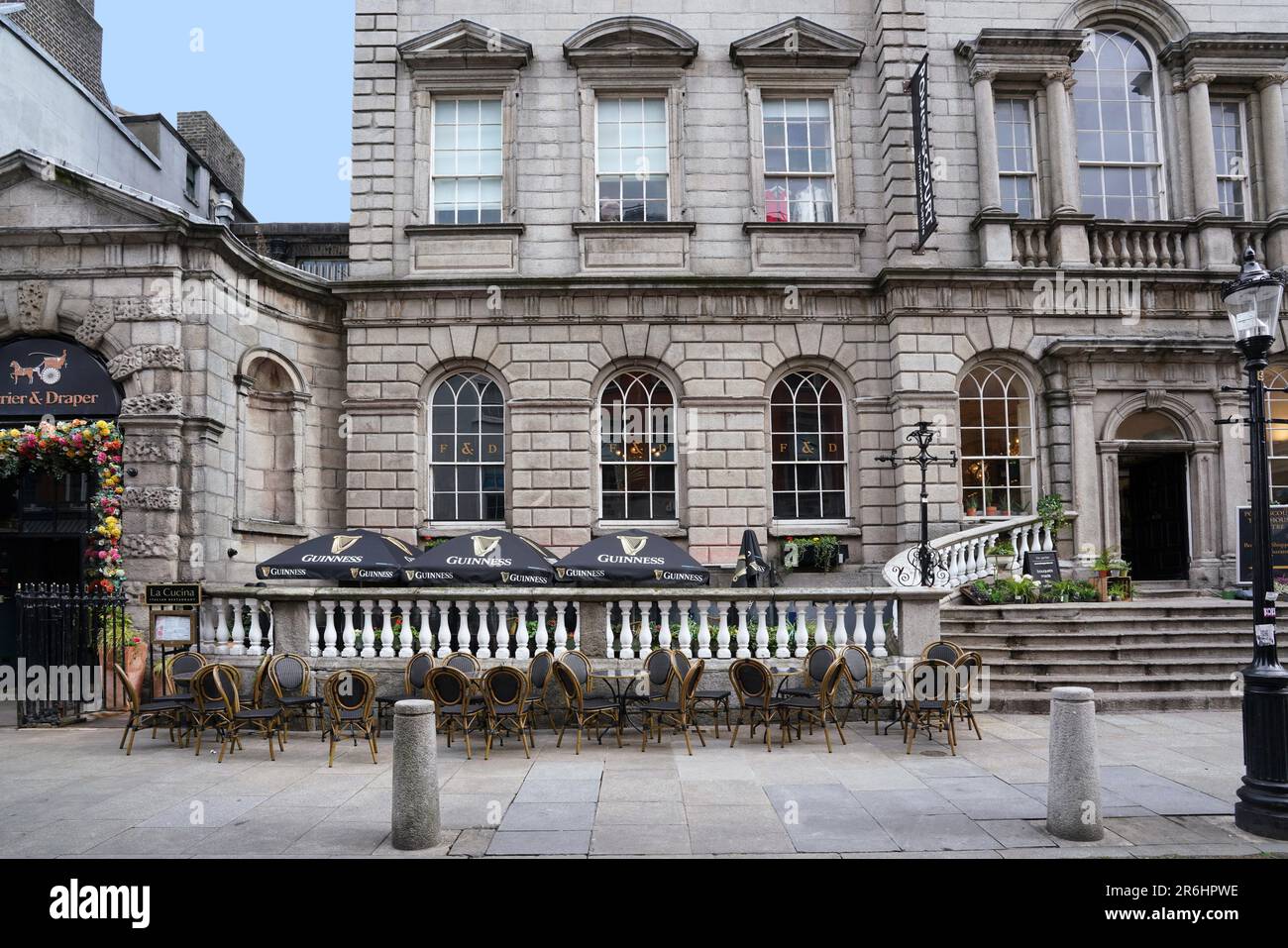 Tables set up for the outdoor patio of a pub in front of an 18th