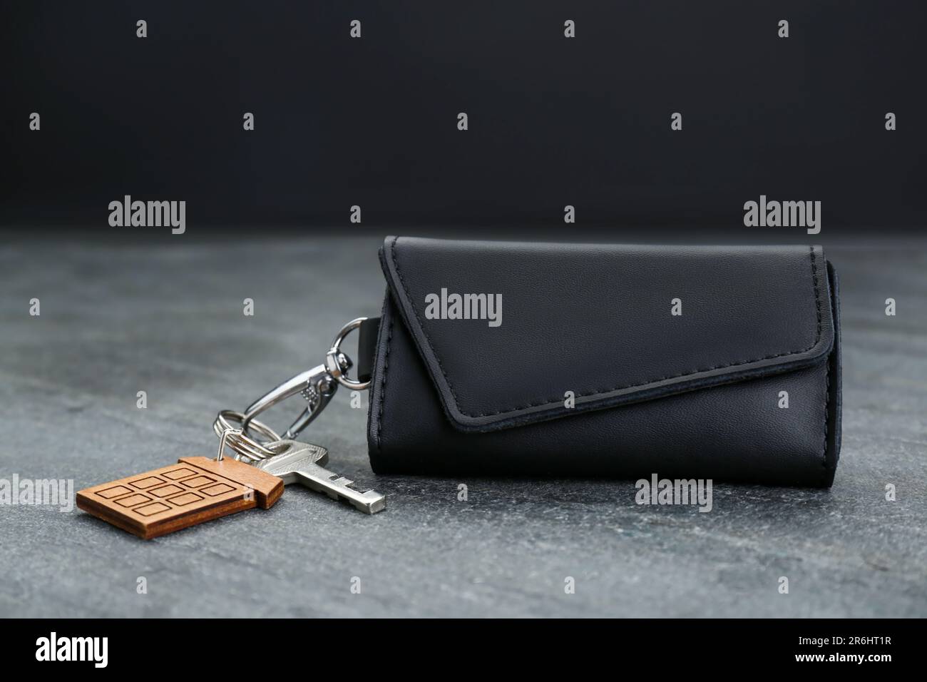 Leather case with key on grey table, closeup Stock Photo