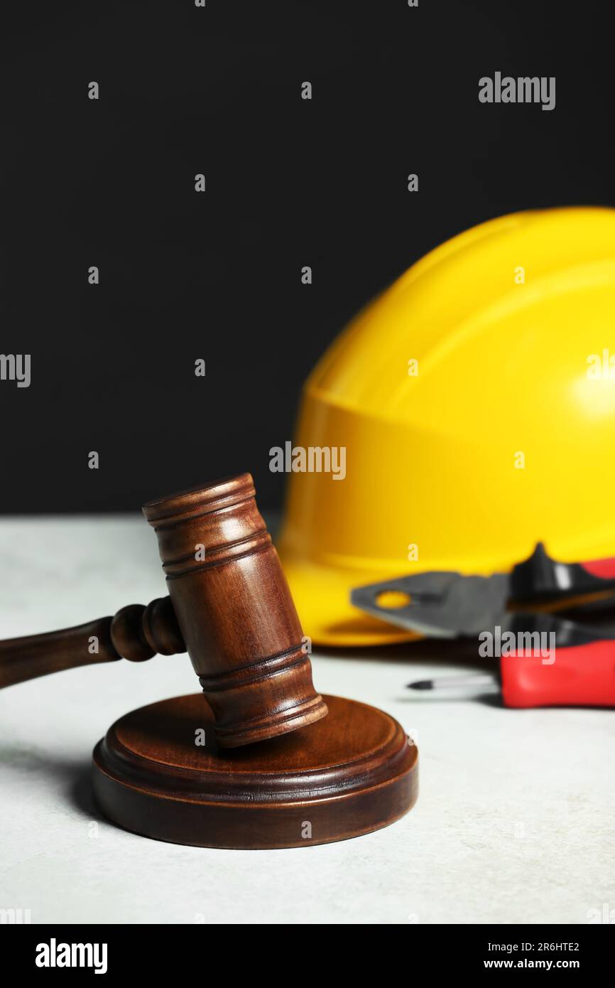 Construction and land law concepts. Gavel, hard hat and different tools on white table Stock Photo