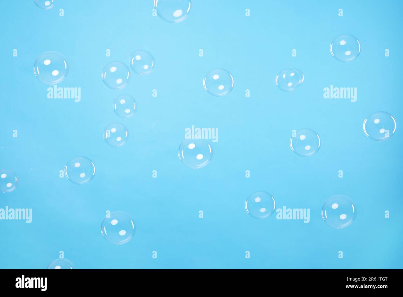 Many beautiful soap bubbles on light blue background Stock Photo - Alamy