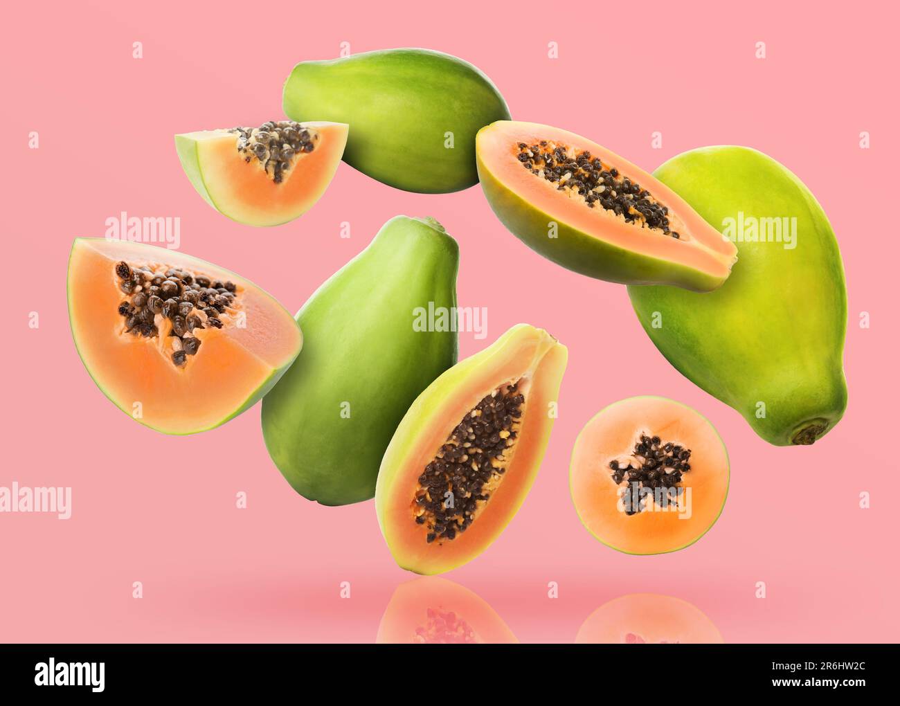 Cut and whole papaya fruits falling on pink background Stock Photo Alamy