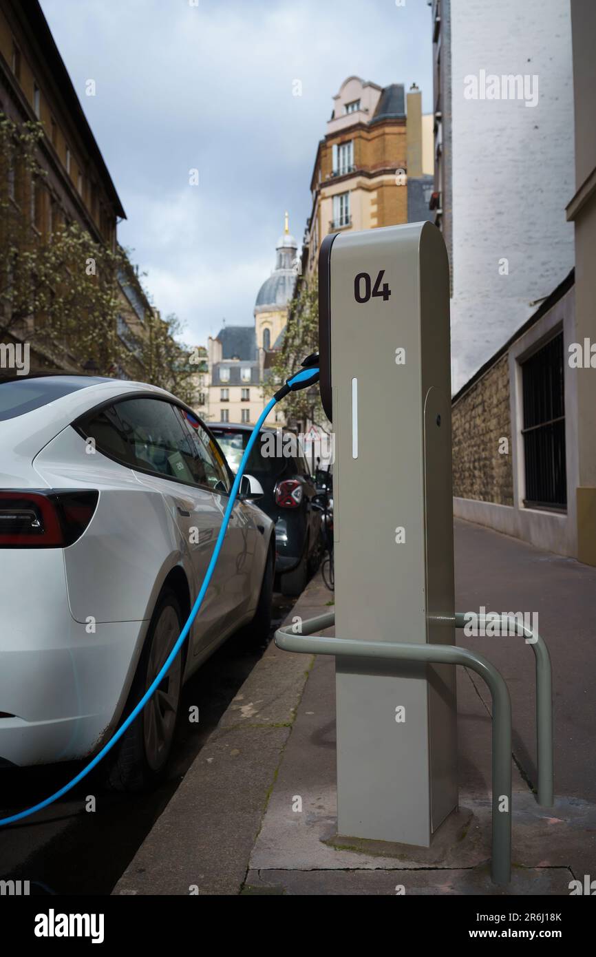 Electric car on EV charging station in the street of Paris, France