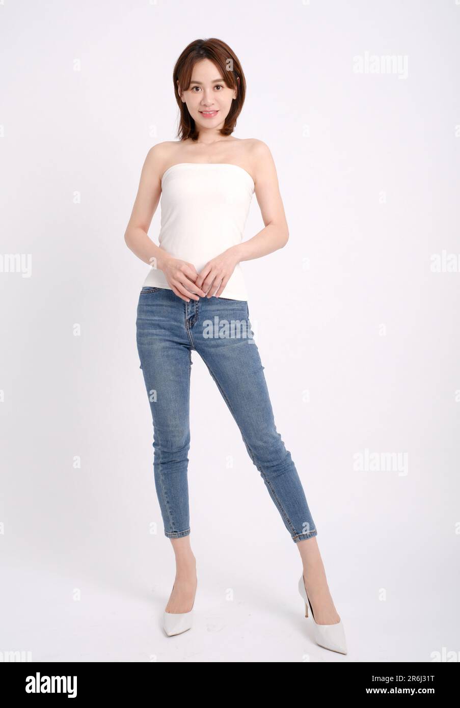 Full length of Happy young  woman posing isolated over white wall background Stock Photo