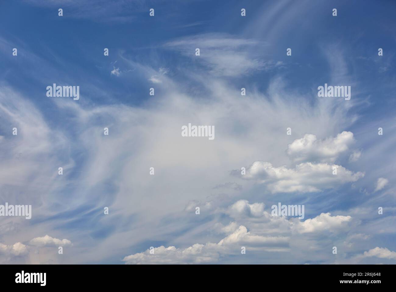 White clouds and ornate haze in the blue sky. Background and texture of the sky above. Stock Photo