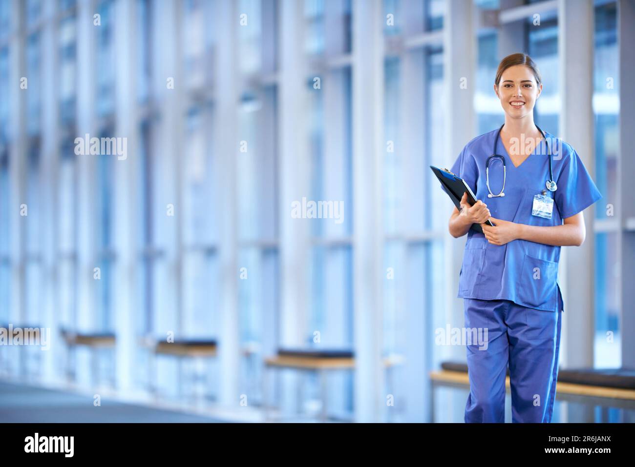 Healthcare, portrait of woman doctor and clipboard standing in a hospital smiling for protection. Nursing, health wellness female nurse or surgeon Stock Photo